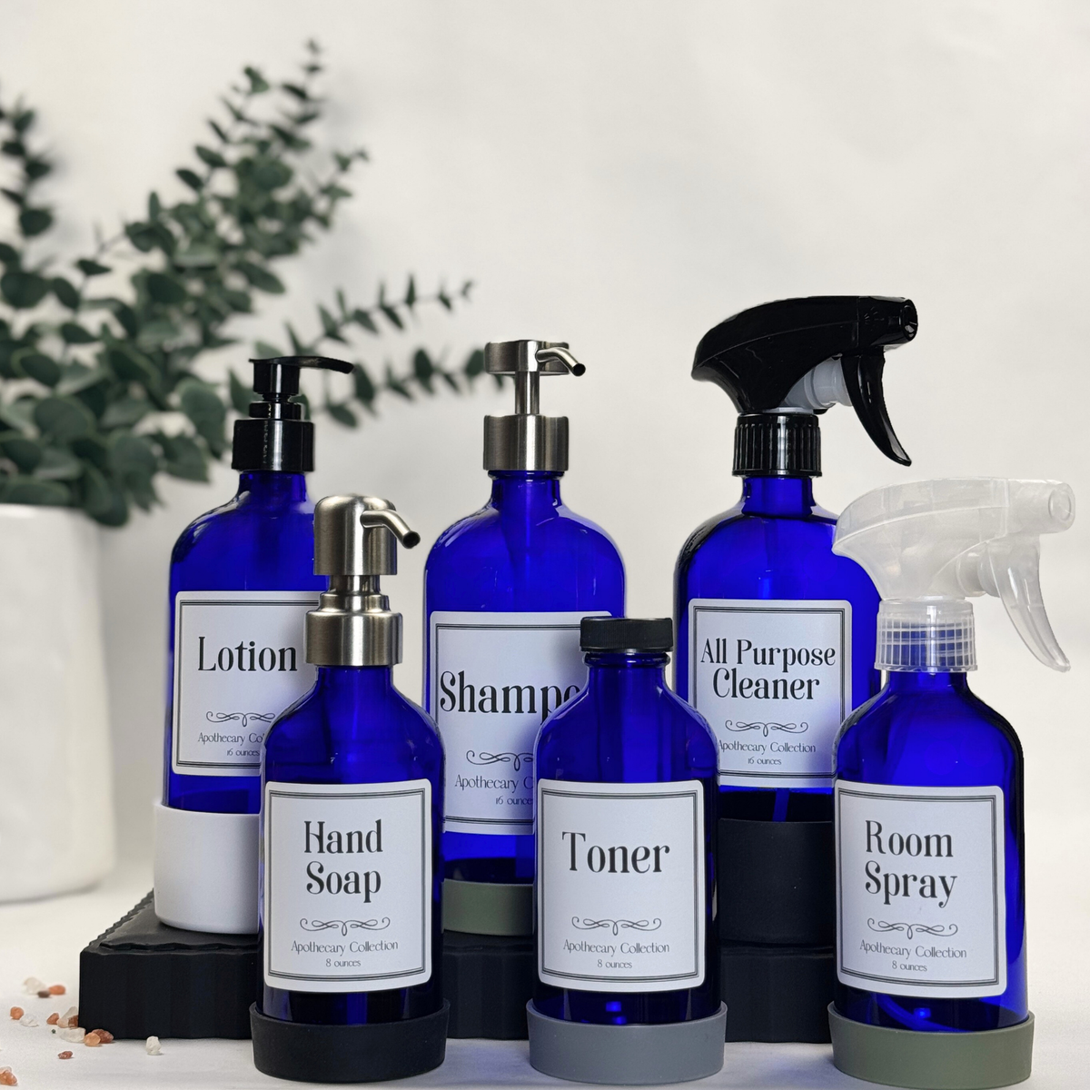 Cobalt blue glass dispenser with silicone sleeve shown with multiple pump and spray top styles