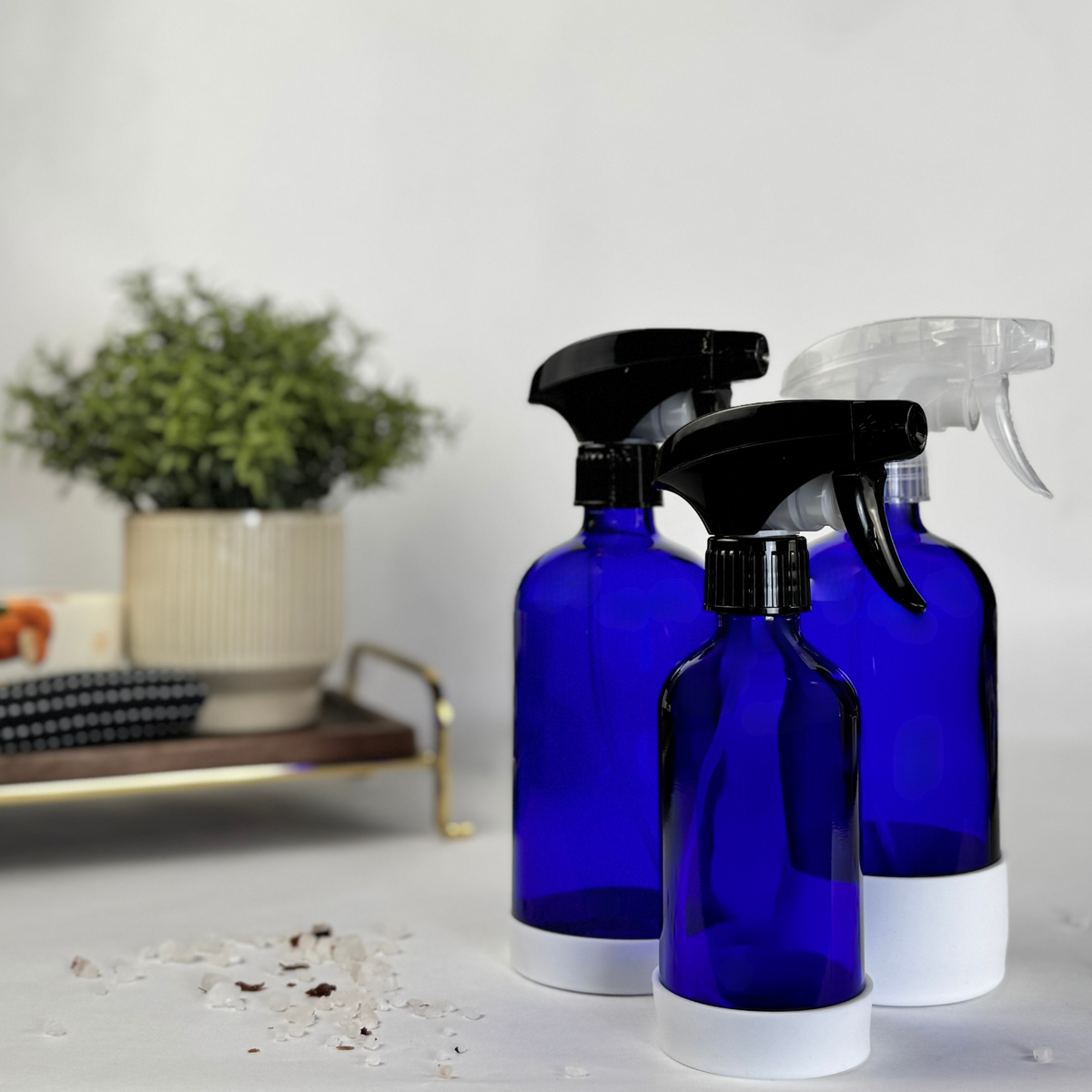Cobalt blue glass dispenser with silicone sleeve showing spray top options