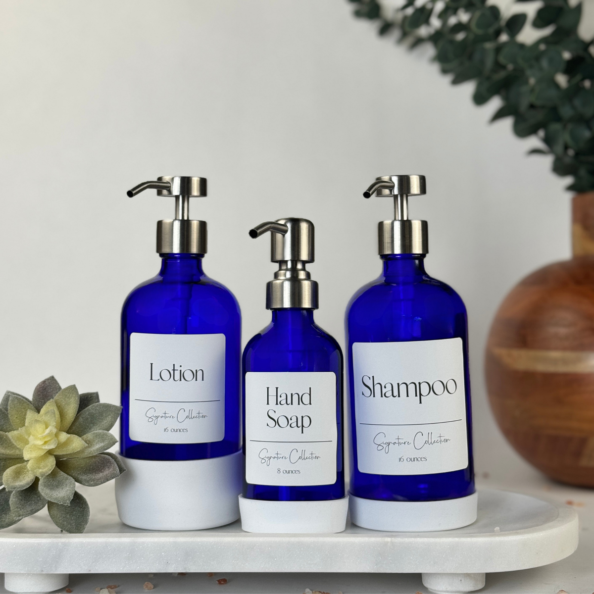Cobalt blue glass dispensers with white silicone sleeves, Signature labels and black pumps